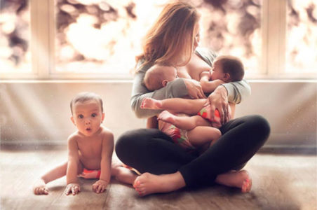 Многодетная мама кормит двоих малышей