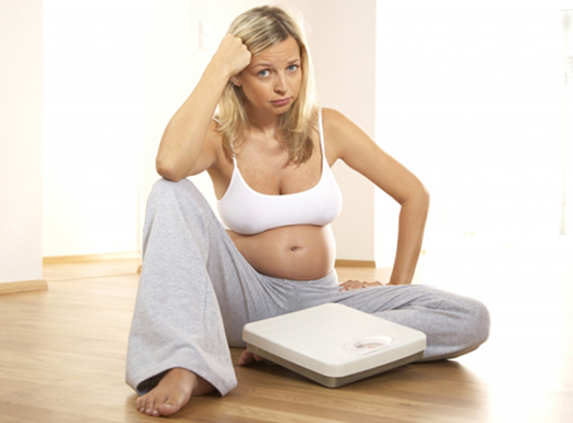 Беременная женщина над весами