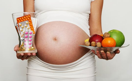 Беременная девушка с лекарствами и фруктами