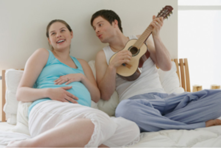 Беременная слушает музыку мужа