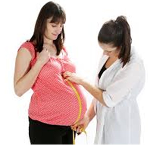 Медсестра меряет живот беременной